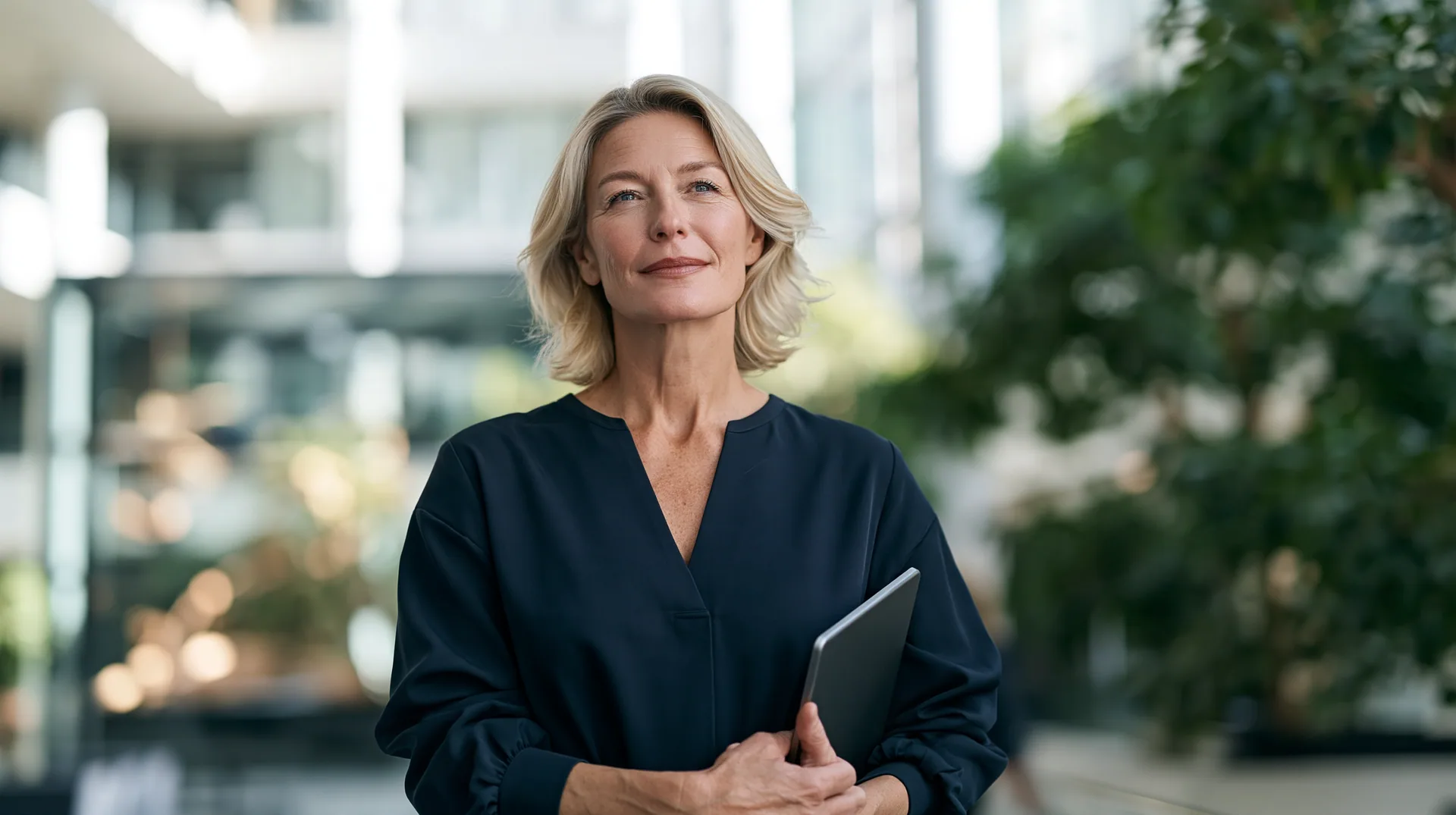 Illustration: a finance leader holding a tablet in a glass office
