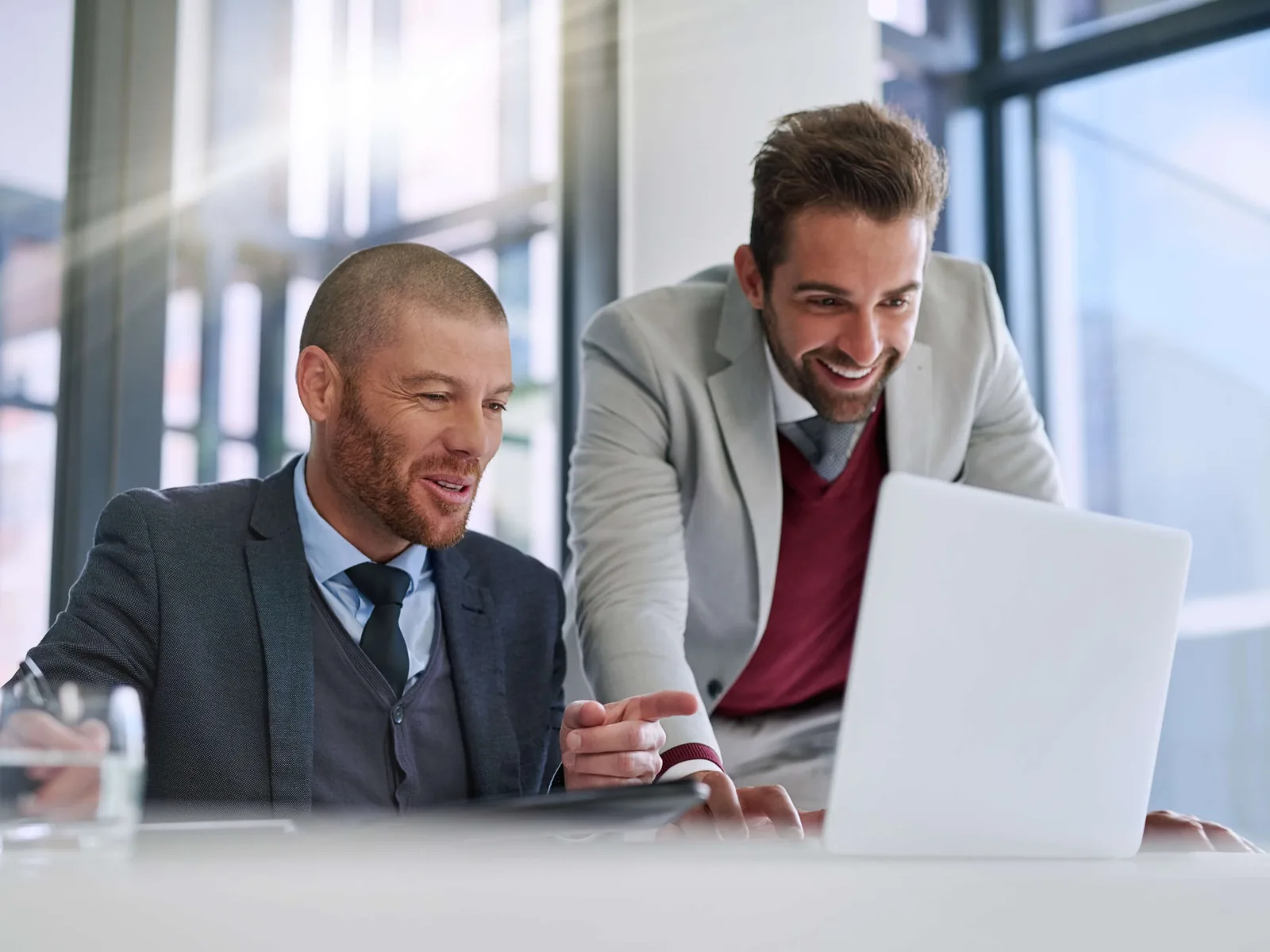 Two consultants reviewing a client's plan together on a laptop