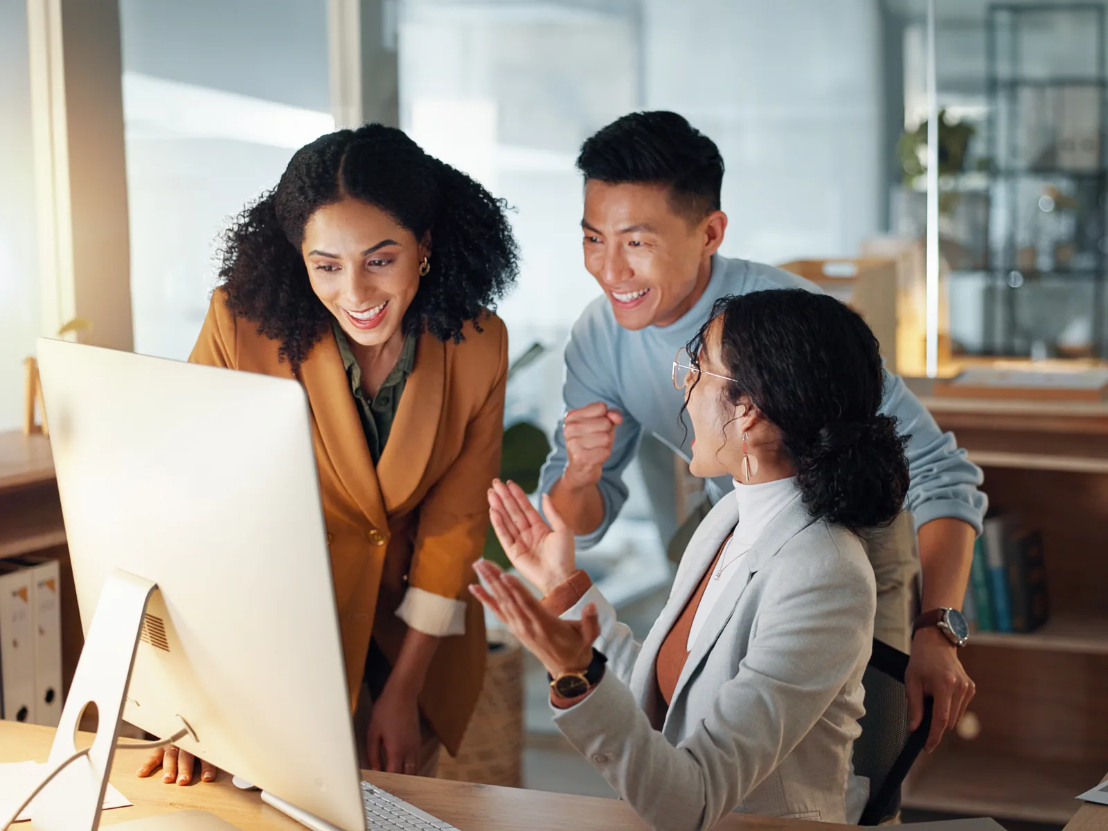 A project team gathered around a monitor, working through a hand-off